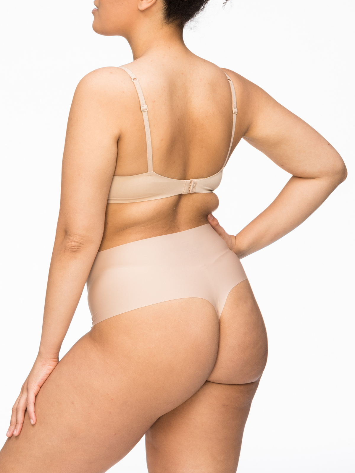 Back view of Nancy Ganz Body Light Waisted Thong featuring seamless bonded construction and smooth finish under clothing.