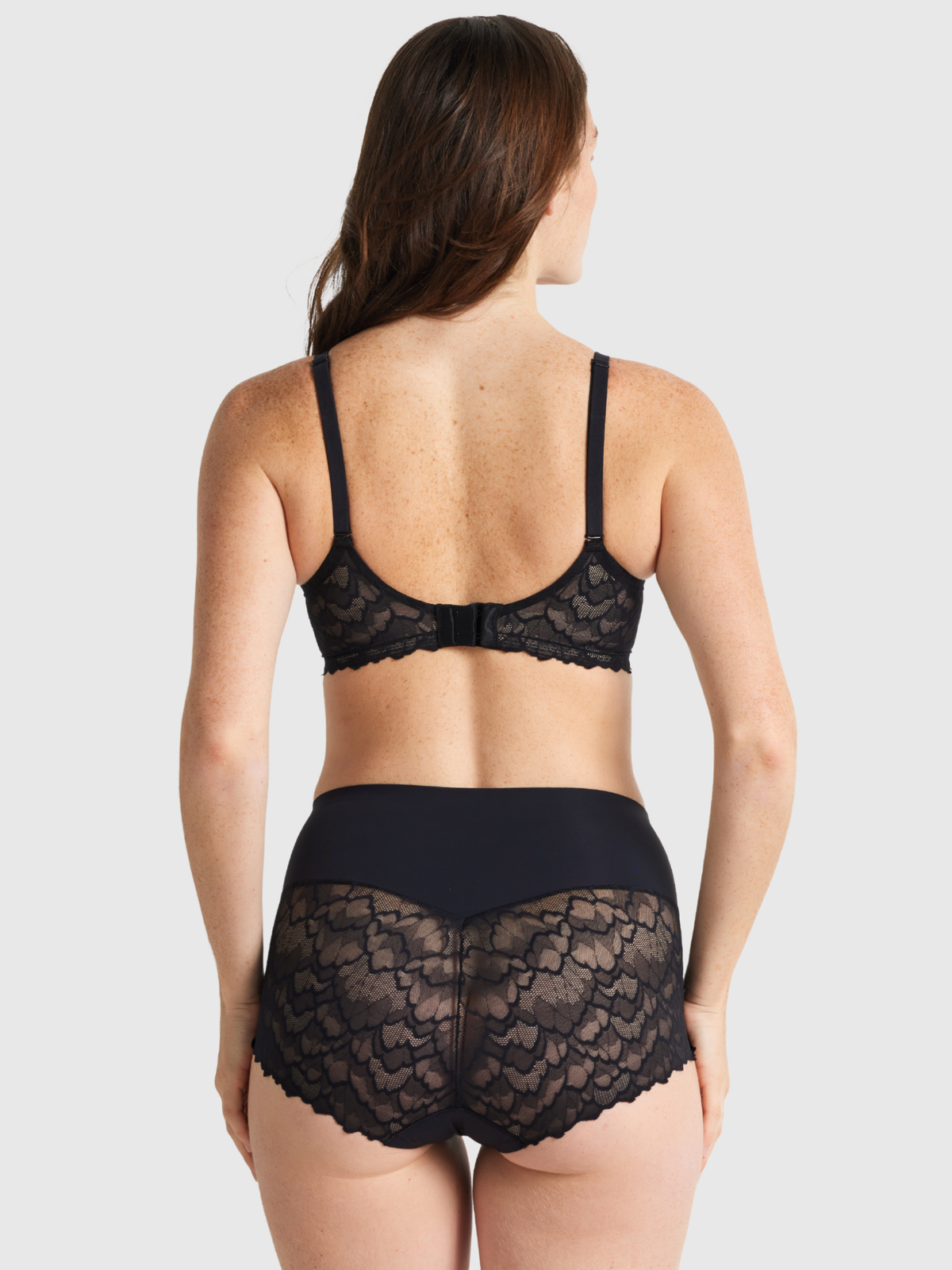 Nancy Ganz Sculpted Lace Waisted Brief in black, back view, showing seamless shaping and scalloped lace trim