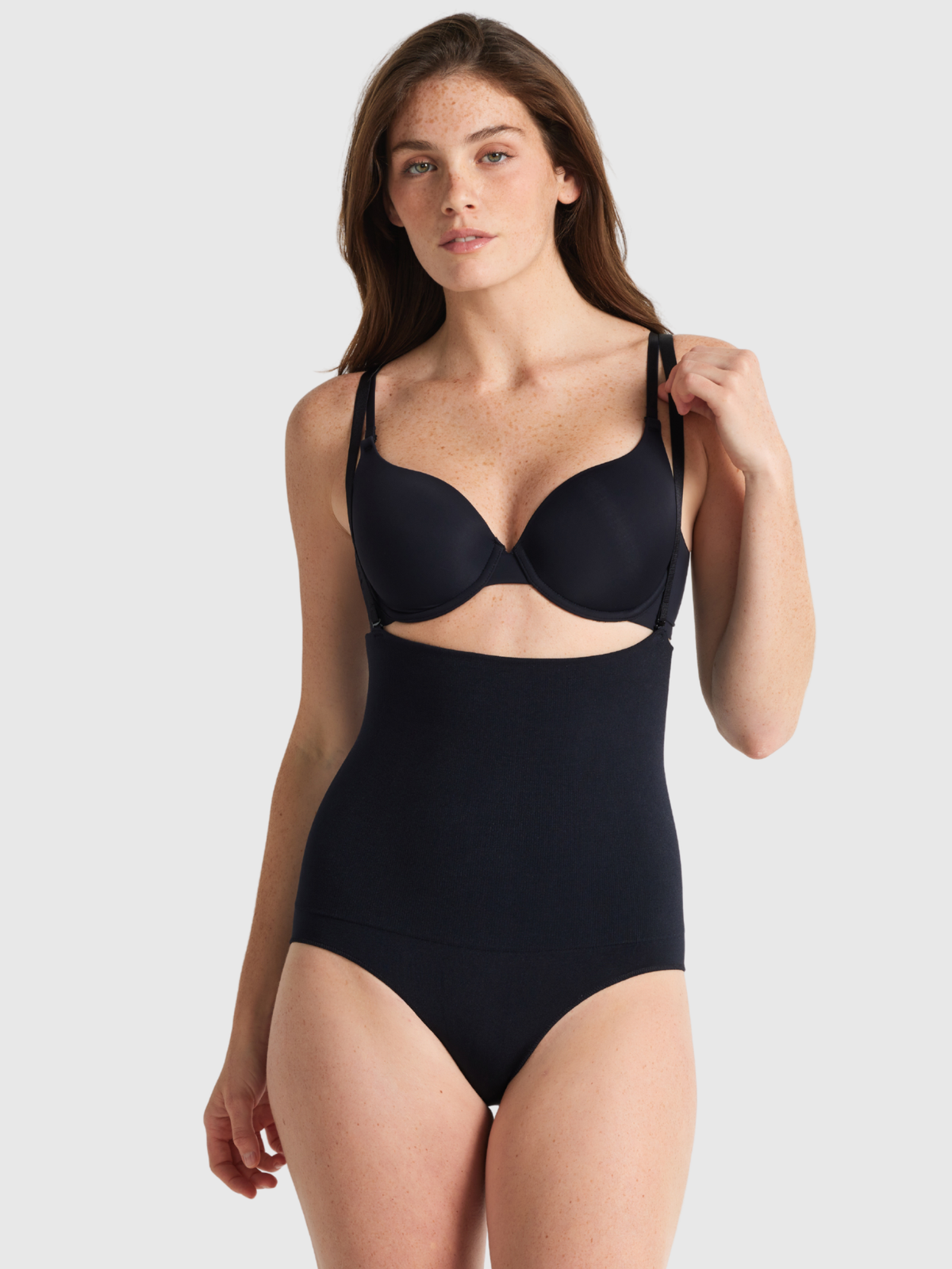 Nancy Ganz Seamless Seduction High Waisted Brief in black, front view with detachable shoulder straps attached over the shoulders.