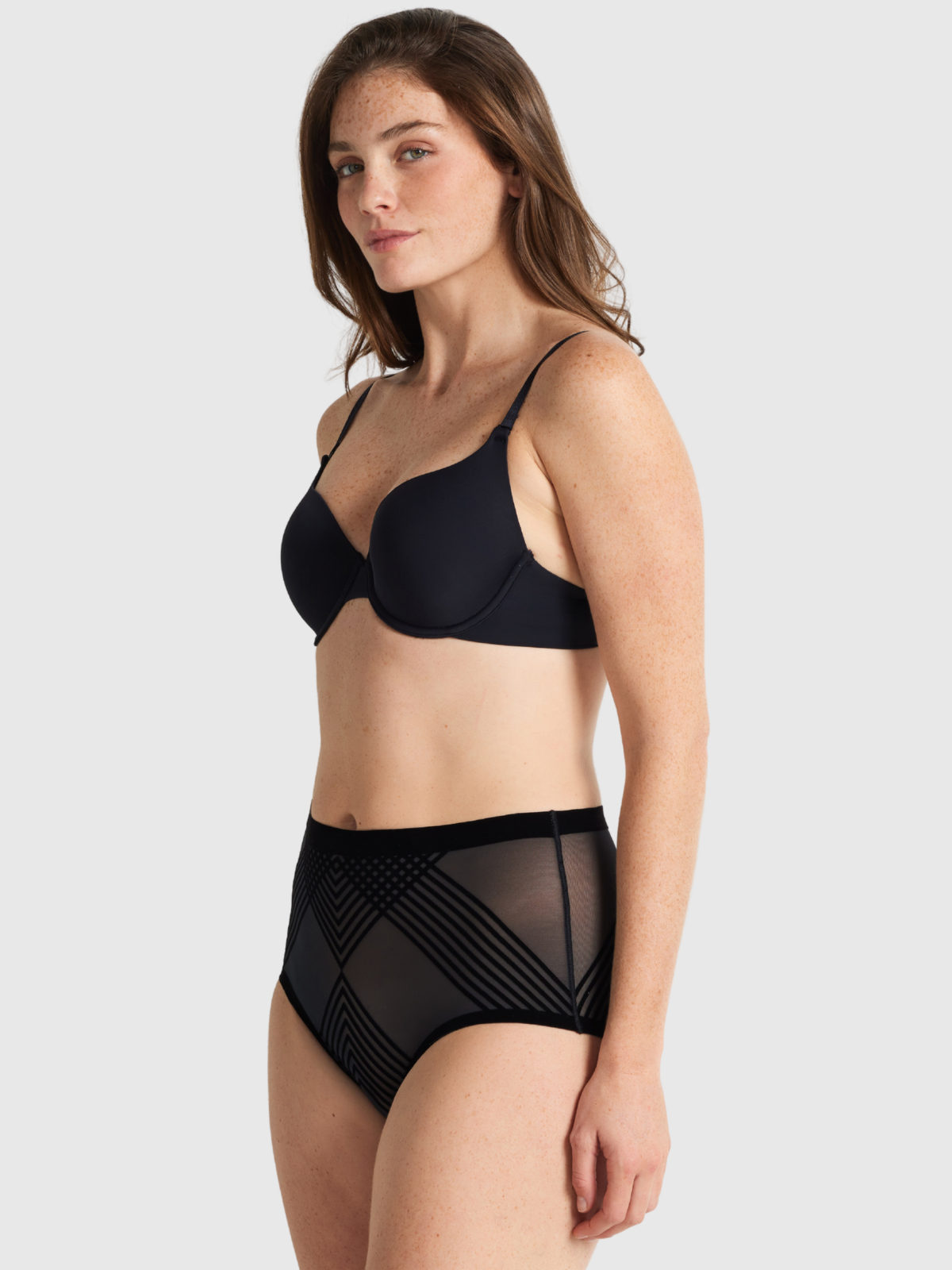 Nancy Ganz Sheer Power Waisted Brief in black, side view showing waistband sitting at the natural waist and firm shaping through the tummy