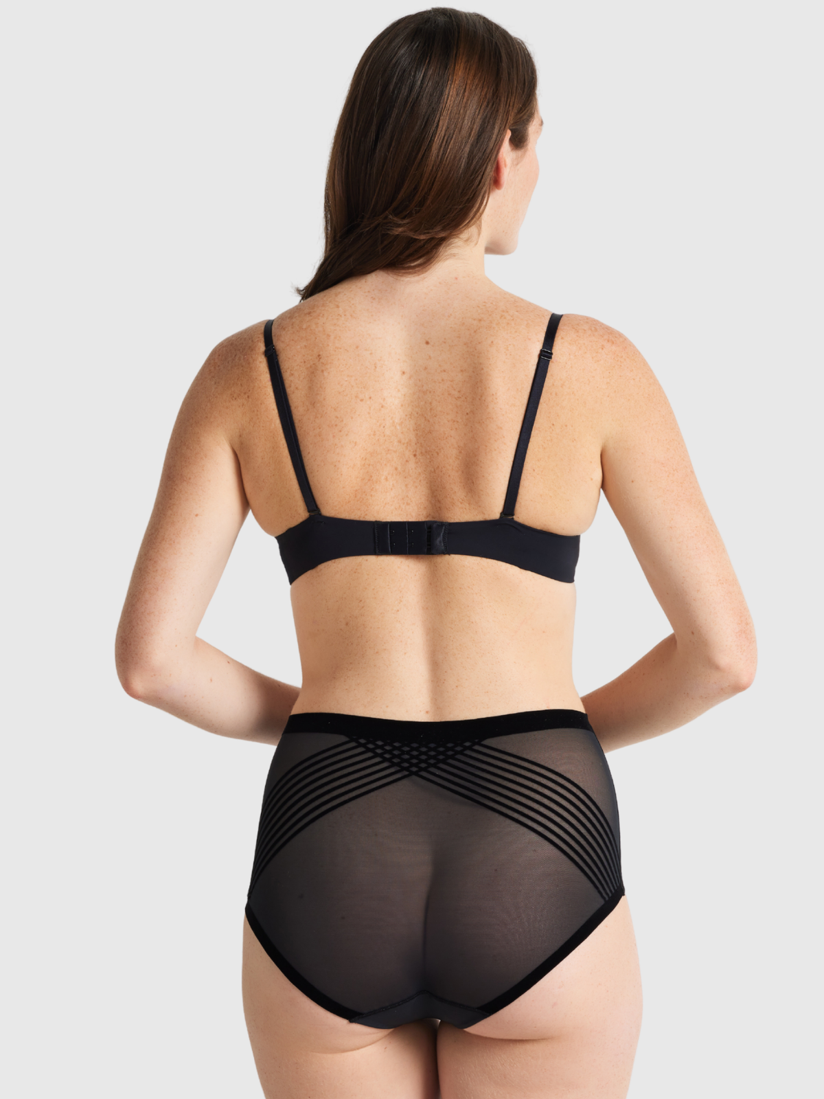 Nancy Ganz Sheer Power Waisted Brief in black, back view showing sheer panelling across the seat and smooth bonded leg edges