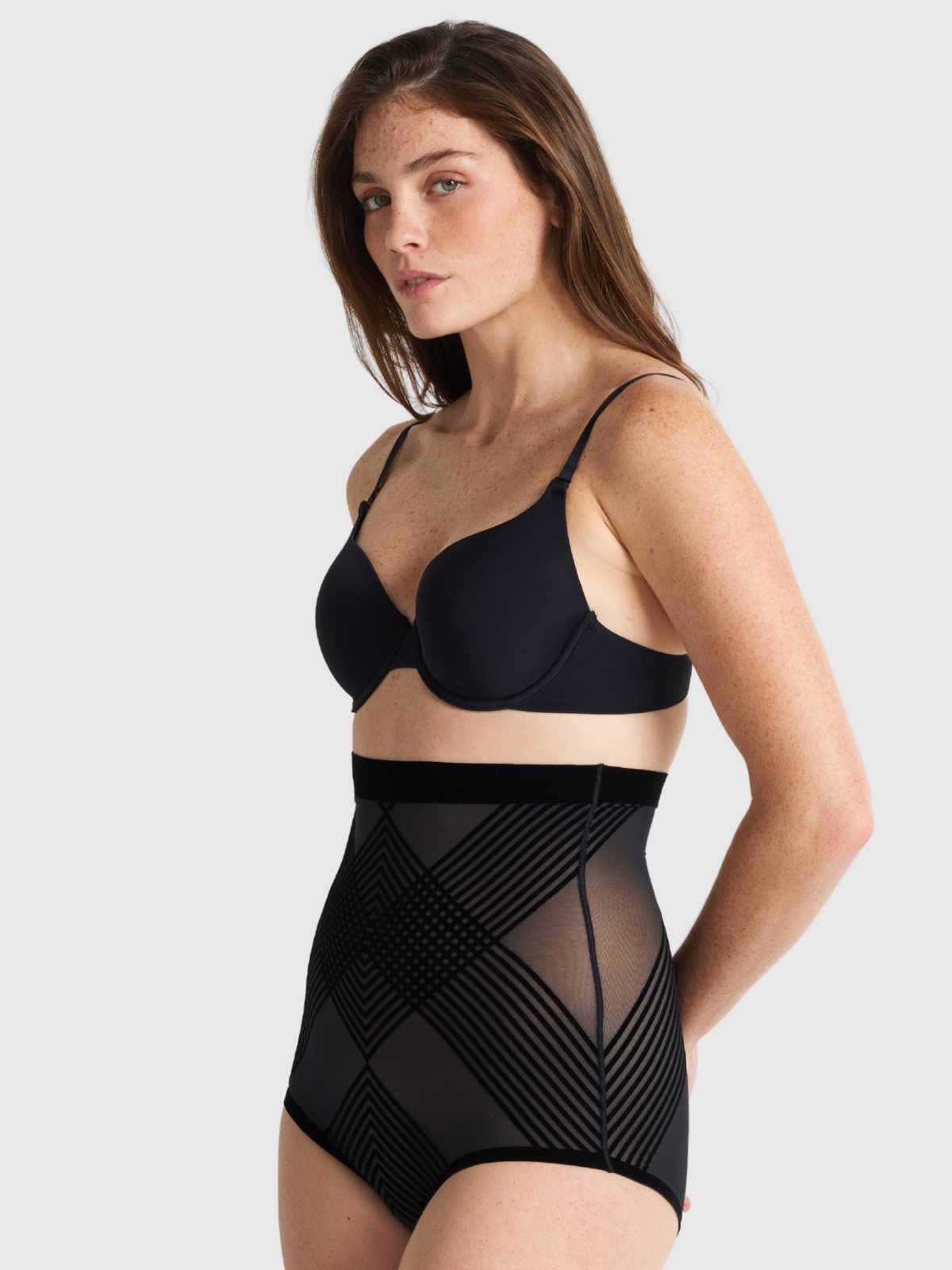 Nancy Ganz Sheer Power High Waisted Brief in black, side view showing the high rise through the midsection and a smooth hip line