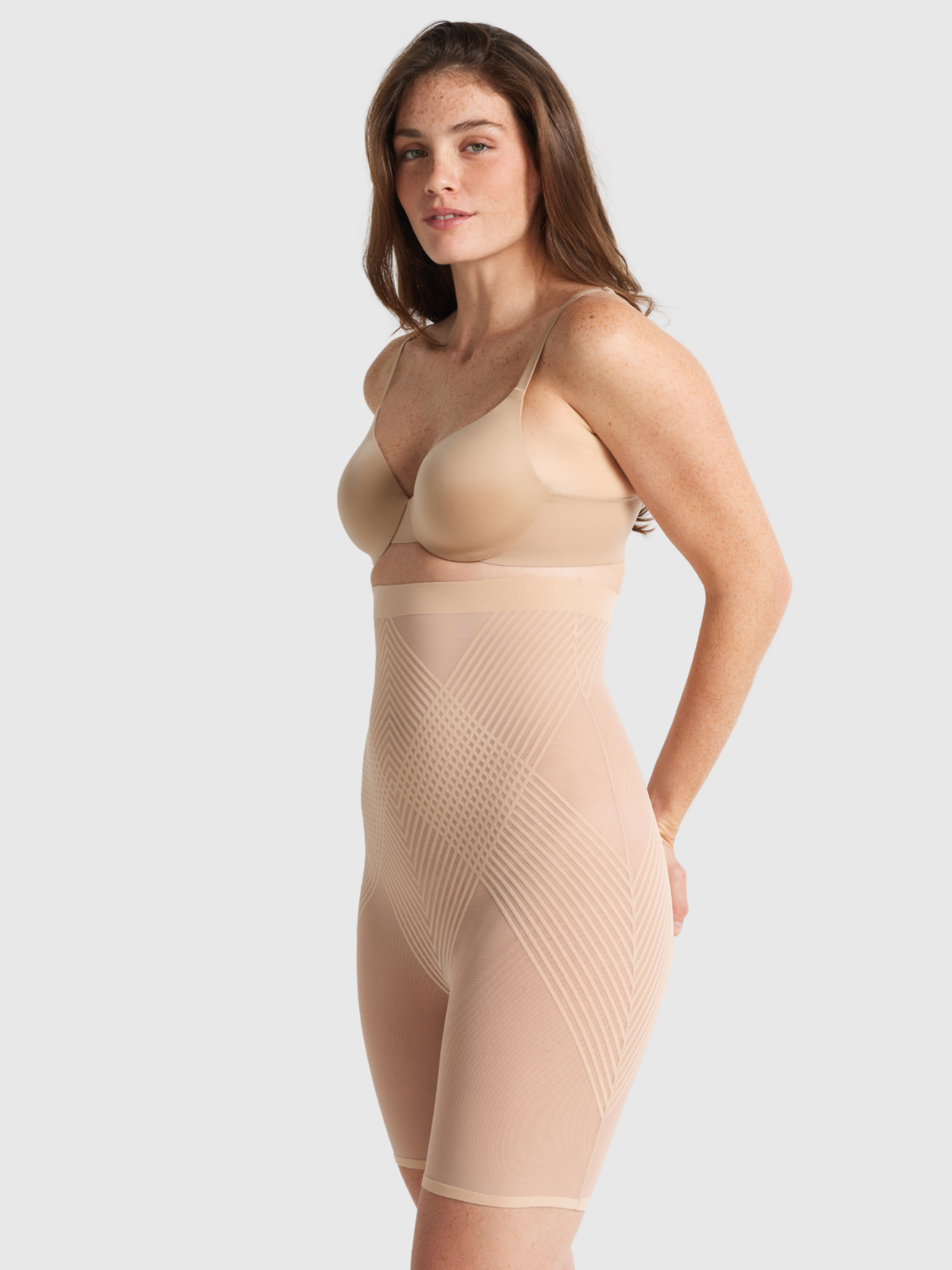 Nancy Ganz Sheer Power High Waisted Thigh Shaper in warm taupe, side view showing high rise coverage and firm shaping down the thigh