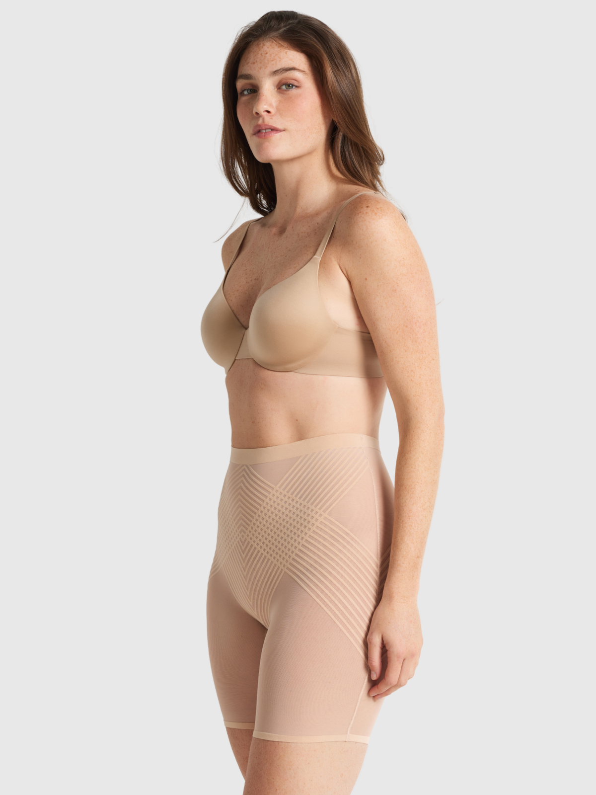 Nancy Ganz Sheer Power Waisted Thigh Shaper in warm taupe, side view showing the natural waist rise and firm shaping down the thigh